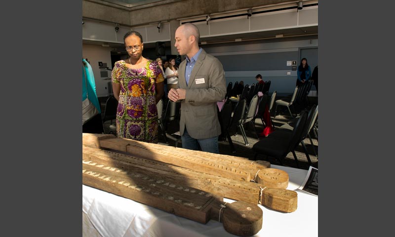 Jean Njeri Kamau, Kenyan Ambassador to the U.S., and Dr. Chip Colwell-Chanthaphonh, curator of anthropology, talk by a display of vigango before the signing ceremony.